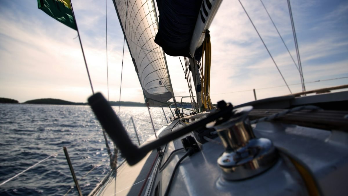 Reel on sailboat with sails sailing on water with horizon in the background